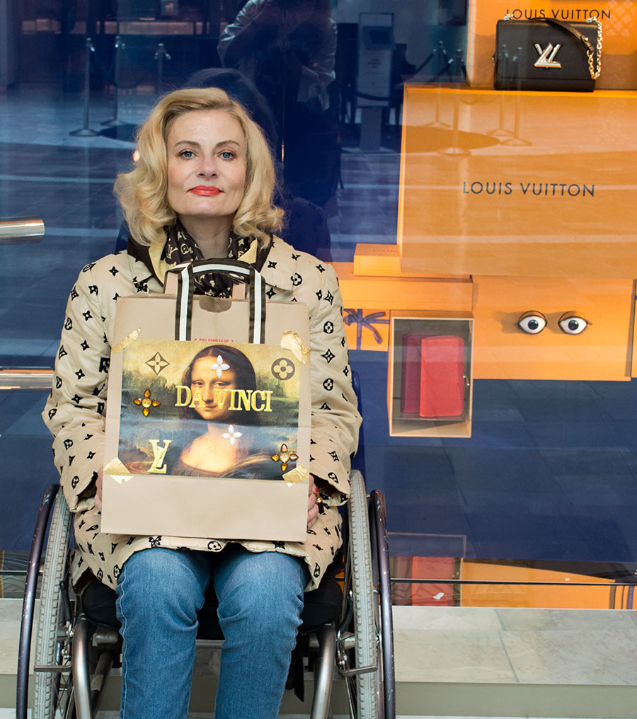 Pretty Cripple holding DIY Mona Lisa Vuitton Koons shopping bag