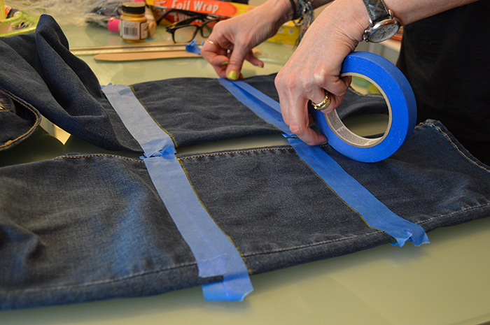 Taping down the DIY jeans project.