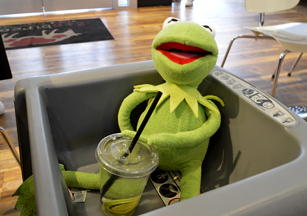 Kermit in a high chair enjoying seltzer and lime